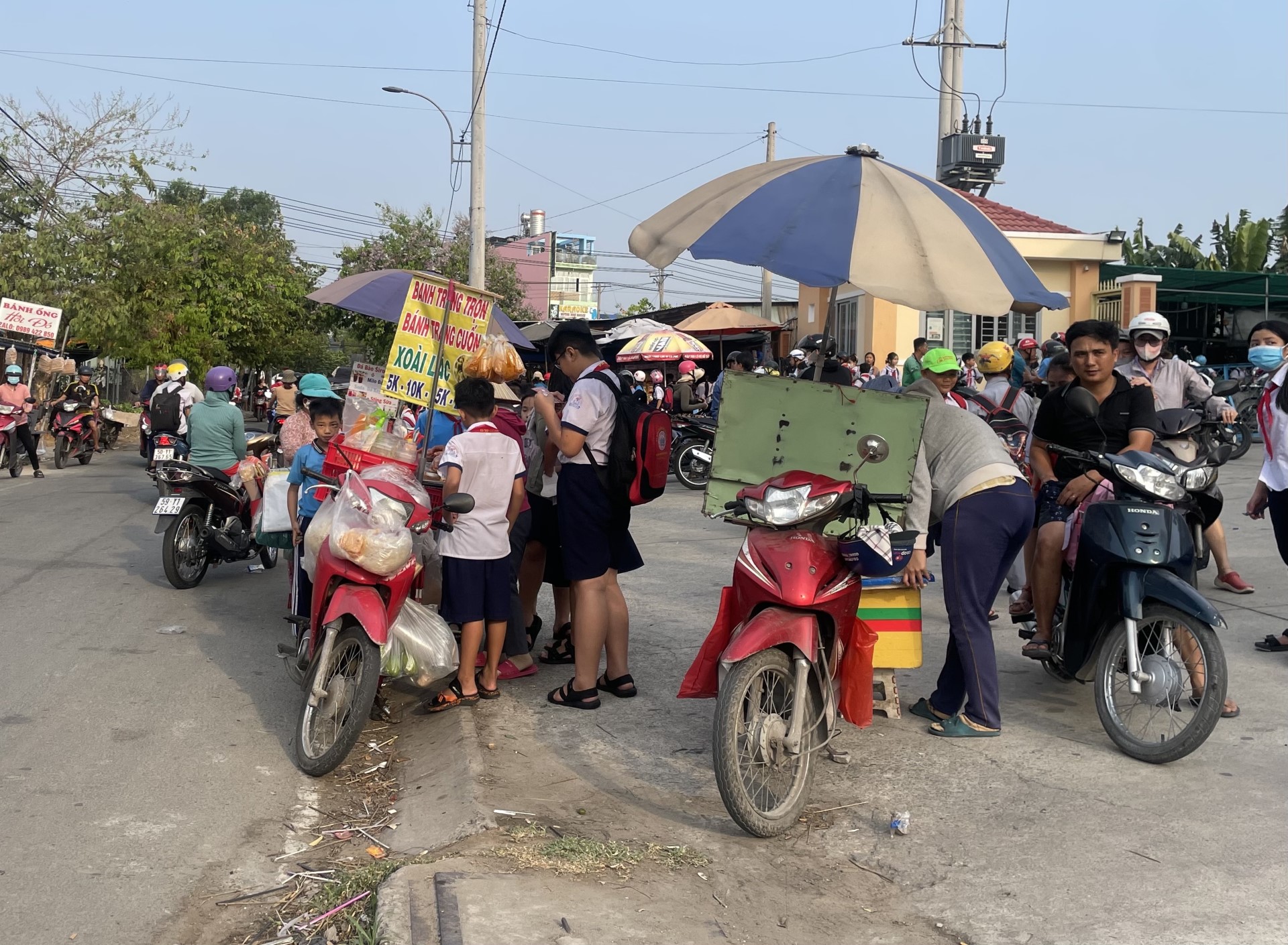 Rất đông trẻ nhỏ mua đồ ăn bày bán trước cổng trường